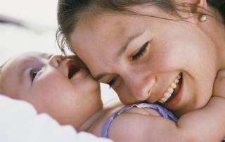 Parent smiling while holding a young child