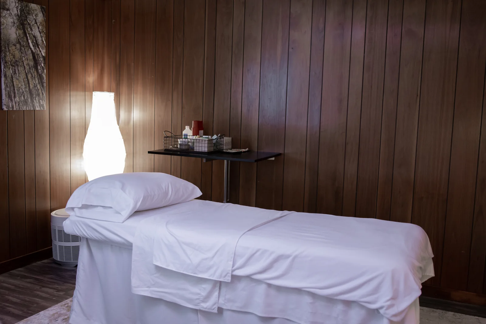 Prepared treatment table in a softly lit wood-panelled clinic room.
